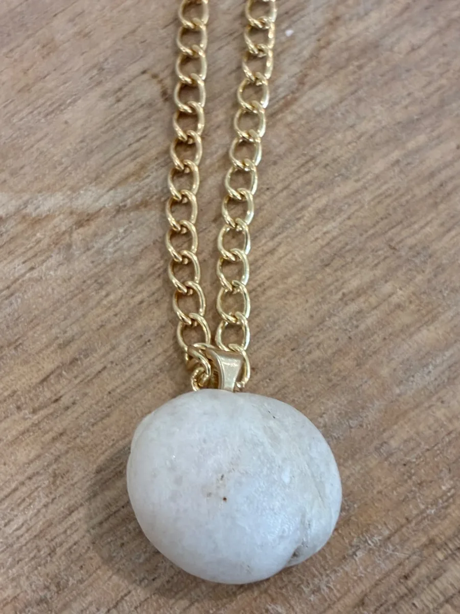 Sea Pearl — rounded white beach stone on a gold-tone bail