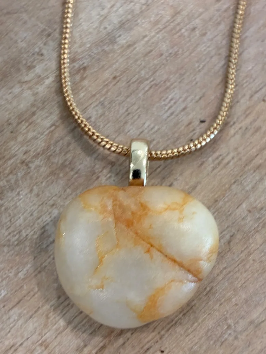 Marbled Heart — white heart-shaped beach stone with amber veining on a gold chain